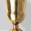 Gold metal urn vase on a plain background