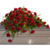 Red carnation spray arranged on a gray casket
