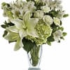 White lilies and green hydrangeas in a clear glass vase