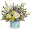 Blue and white floral arrangement in a light blue glass vase