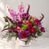 Mixed bouquet in a white round box with pink orchids and red roses