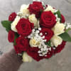 Handheld bouquet of red and white roses with baby's breath