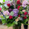 Bouquet of red roses and lavender flowers in a glass vase