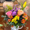 Bright and cheery arrangement in a deacorative tea cup. 