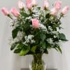 Pink roses arranged in a clear glass vase with white filler flowers