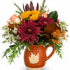Autumn bouquet in a ceramic pitcher with burgundy, yellow, and peach flowers