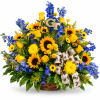 Basket arrangement of yellow roses, sunflowers, and blue flowers with a bee ribbon