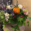 Mixed bouquet with orange, pink, purple, and white flowers in a vase