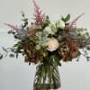 Mixed bouquet of white and blush flowers in a glass vase
