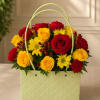 Basket arrangement of red and yellow roses with daisies and carnations