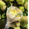 Yellow and white bouquet wrapped in cream paper with a ribbon