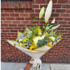 Handheld bouquet with white lilies, roses, and yellow flowers wrapped in white paper