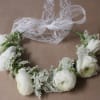 White flower crown with lace ribbon on a brown background