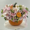 Classic orange pumpkin with an arrangement of fresh pastel flowers
