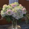 Pastel hydrangea and pink chrysanthemum arrangement in a clear glass vase