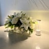 White lilies and hydrangeas in a clear glass vase