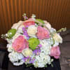 Basket arrangement of pink and white roses with white hydrangeas and green mums