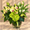 Yellow orchids and white tulips arranged in a glass vase