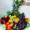 Fruit basket with roses, grapes, pineapple, apples, and a jar of strawberries