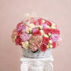 Basket of pink and cream roses with hydrangeas and a ribbon bow