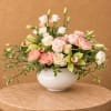 Mixed pastel flower arrangement in a white bowl vase