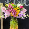 Mixed bouquet of orchids and lilies in a clear glass vase