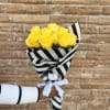 Bouquet of yellow roses wrapped in black-and-white striped paper