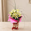 Bouquet of white lilies wrapped in bright pink paper with a ribbon