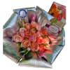 A lush cluster of peach roses with soft pink tulips creates a