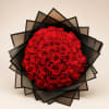 Round bouquet of red roses wrapped in black paper