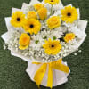 Yellow roses and gerbera daisies in white wrapping with a yellow ribbon