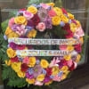 Large floral wreath with colorful roses and ribbons reading "RECUERDOS DE PANCHO"