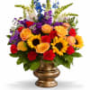 Colorful mixed flower arrangement in a gold vase