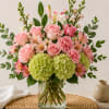 Pink roses and carnations with green hydrangeas in a glass vase