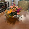 Pumpkin-shaped floral arrangement with peach roses and purple blooms