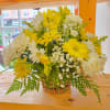 Yellow and white daisy bouquet in a woven basket