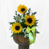 Basket arrangement with sunflowers, small white daisies, and a yellow ribbon