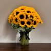 Bouquet of yellow sunflowers in a glass vase with a black ribbon