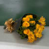 Yellow roses and yellow flowers wrapped in black paper with a gold bow