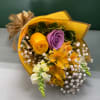Bouquet of yellow, purple, and orange flowers wrapped in gold paper