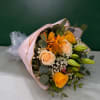 Bouquet of peach and yellow roses with orange lilies wrapped in pink paper
