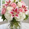 Pink roses and stargazer lilies in a clear glass vase