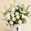 White floral arrangement in a white hatbox with lilies and roses