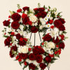 Heart-shaped wreath of red and white flowers on a stand