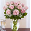 Pink roses arranged in a clear glass vase with white filler flowers