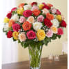 Mixed roses in a clear glass vase on a table