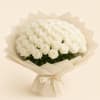 Large bouquet of white roses wrapped in cream paper with a satin bow