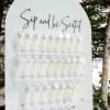 White seating chart board with rows of champagne flutes