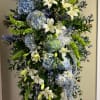 Tall standing floral spray with blue hydrangeas and white lilies