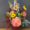 Mixed bouquet with sunflowers and pink hydrangea in a red vase